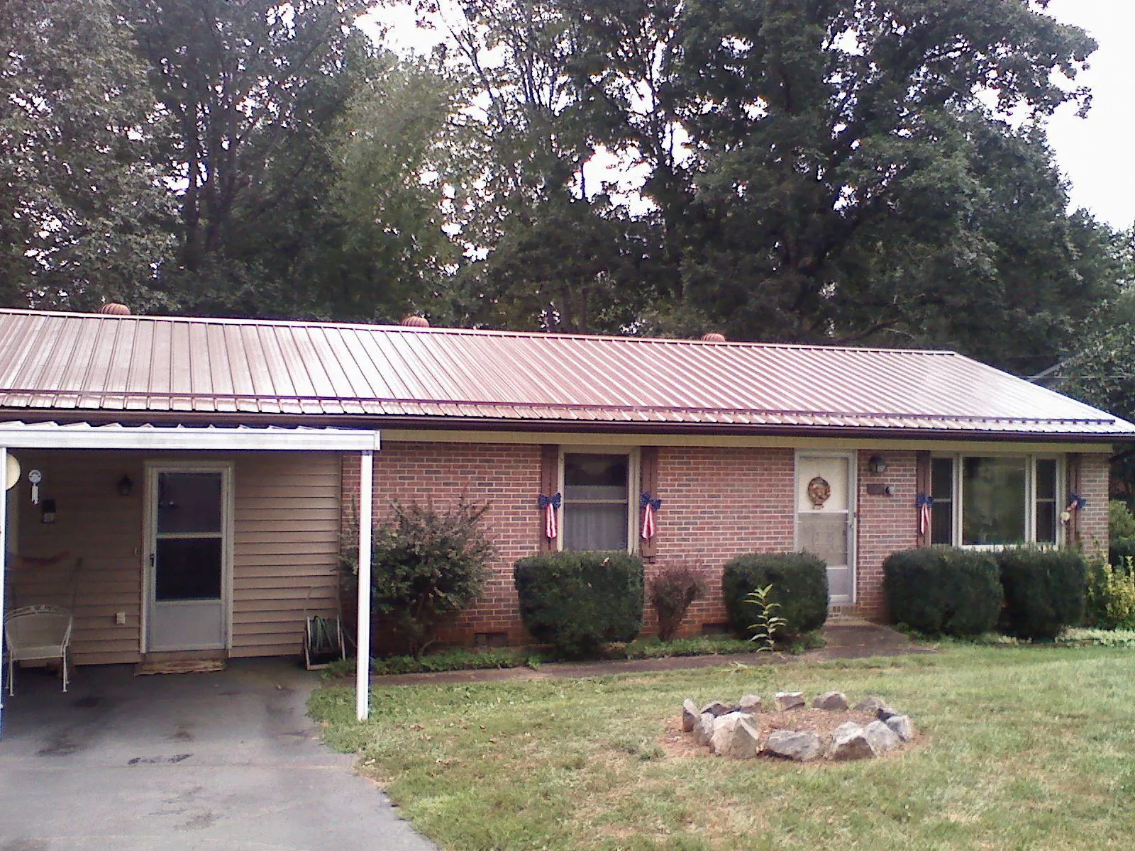 Bronze metal roof and carport on a brick ranch home in Brimfield